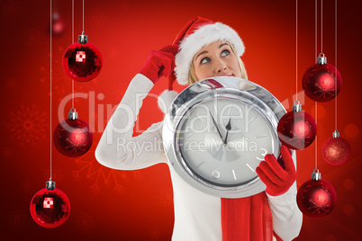 Composite image of festive blonde holding a clock Composite image of festive blonde holding a clock