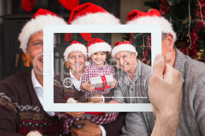 Composite image of hand holding tablet pc