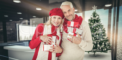 Composite image of happy festive couple with gifts