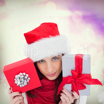 Composite image of cheerful brunette holding christmas gifts