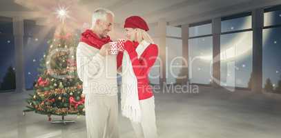 Composite image of happy winter couple with mugs