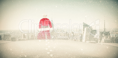 Composite image of rear view of santa claus holding a sack