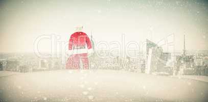 Composite image of rear view of santa claus holding a sack