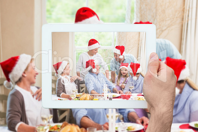 Composite image of hand holding tablet pc