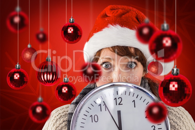 Composite image of woman holding a large clock