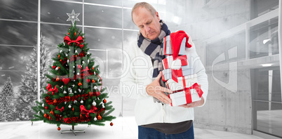 Composite image of festive man holding christmas gifts