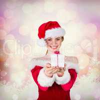 Composite image of pretty girl in santa costume holding gift box