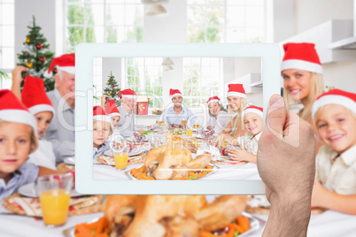 Composite image of hand holding tablet pc