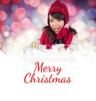 Composite image of surprised young woman holding a wrapped gift