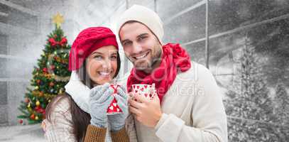 Composite image of winter couple holding mugs