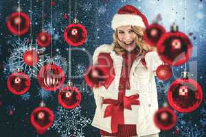 Composite image of festive blonde holding christmas gift and poi