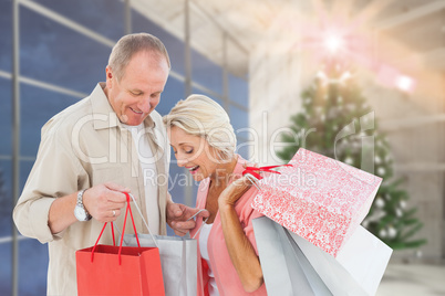 Composite image of couple with shopping bags