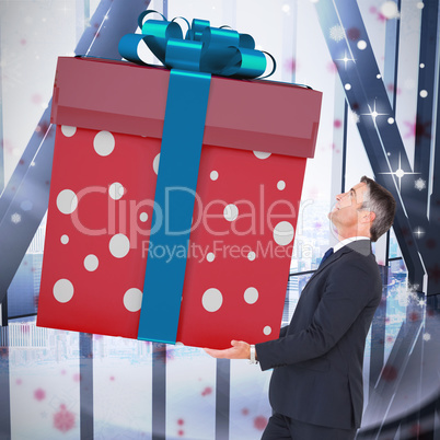 Composite image of stylish man with giant gift