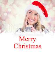 Composite image of festive blonde holding christmas gift and bag