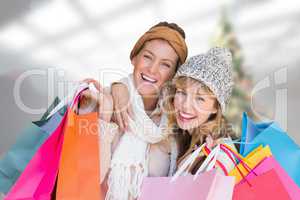 Composite image of smiling women looking at camera with shopping