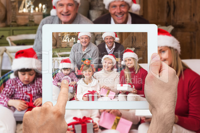 Composite image of hand holding tablet pc