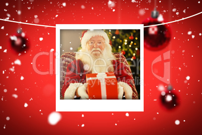 Composite image of santa claus offering a red gift