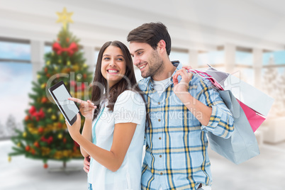 Composite image of happy couple with shopping bags