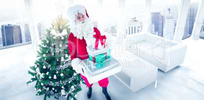 Composite image of happy santa claus holding pile of gifts