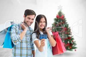 Composite image of couple with shopping bags and credit card