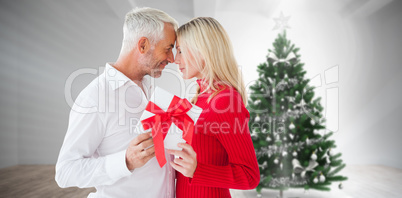 Composite image of loving couple with gift