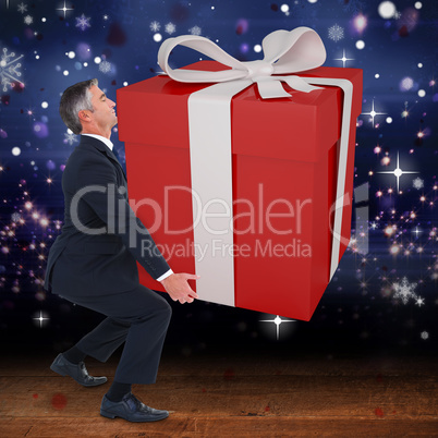 Composite image of stylish man with giant gift