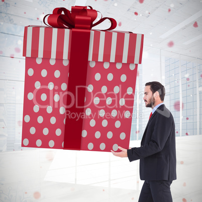 Composite image of stylish man with giant gift