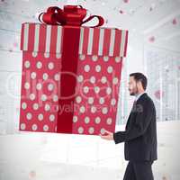 Composite image of stylish man with giant gift