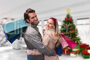 Composite image of smiling couple with shopping bags embracing