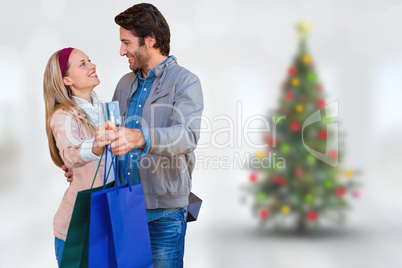 Composite image of smiling couple showing credit card and shoppi