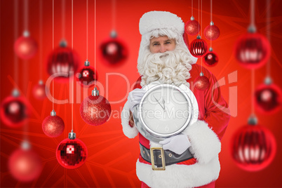 Composite image of happy santa holding a clock