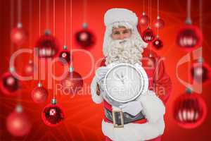 Composite image of happy santa holding a clock