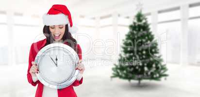 Composite image of excited brunette holding a clock