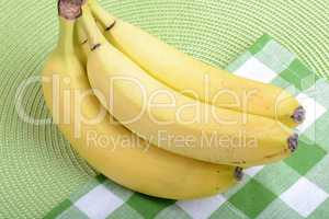 Bunch of ripe bananason green material background