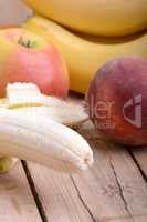 fruits on table, apple, bananas, peach close up, health food concept