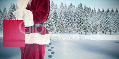 Composite image of santa carries red gift bag