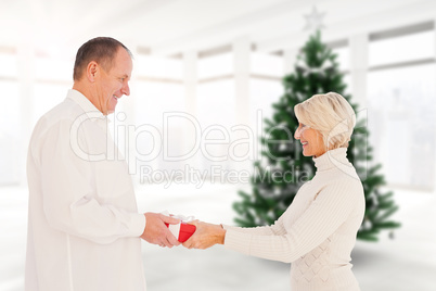 Composite image of couple exchanging gift