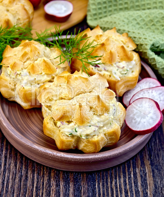 Appetizer of radish and cheese in profiteroles on clay plate wit