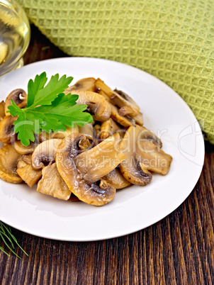 Champignons fried in plate with oil on light board