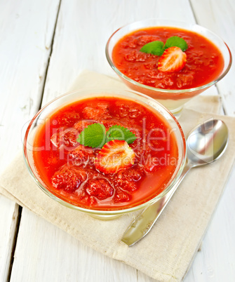 Dessert strawberry-vanilla in two glassful with spoon on board