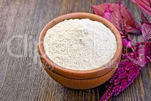 Flour amaranth in clay bowl on board