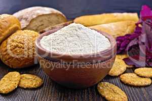 Flour amaranth in clay bowl with bread on board