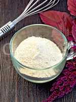 Flour amaranth in glass cup on board with mixer