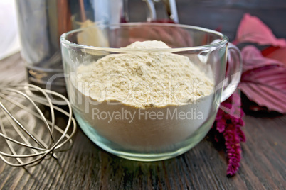 Flour amaranth in glass cup with mixer on board