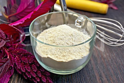 Flour amaranth in glass cup with rolling pin on board