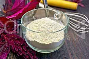Flour amaranth in glass cup with rolling pin on board