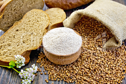 Flour buckwheat in bowl with grains on board