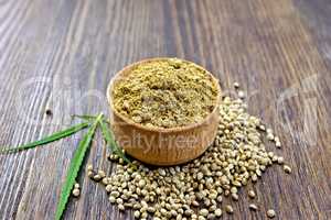 Flour hemp in bowl of grain and leaf on board