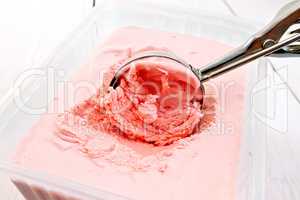 Ice cream strawberry in scoop and tray on board