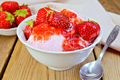 Ice cream strawberry in white bowl and spoon on board